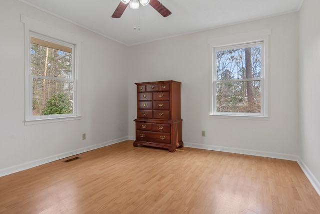 empty room featuring ceiling fan, light wood-type flooring, and crown molding