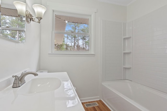 bathroom featuring sink, crown molding, shower / bathtub combination, and a wealth of natural light