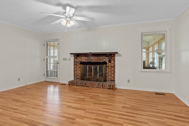 unfurnished living room featuring light wood-type flooring, crown molding, and a fireplace