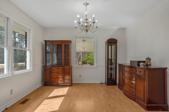 dining area featuring light wood-type flooring and a notable chandelier