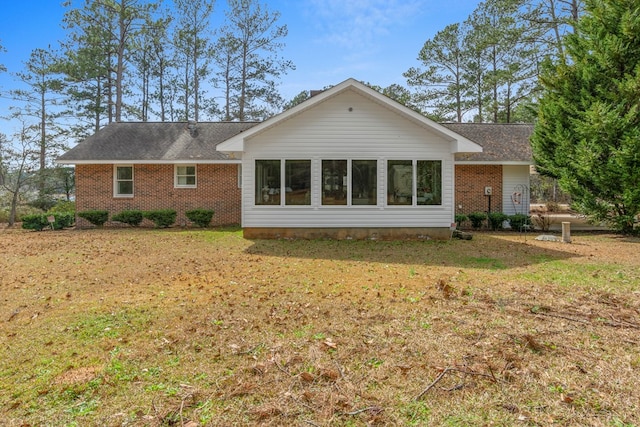 rear view of property featuring a lawn