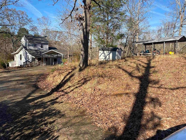 view of yard with a carport and a shed