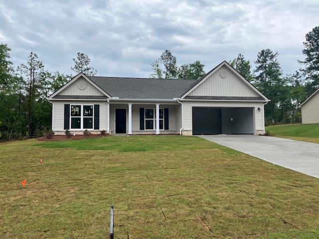 453 Riley Cir, Milledgeville, GA 31061 - ranch-style home featuring driveway, an attached garage, a front lawn, and board and batten siding