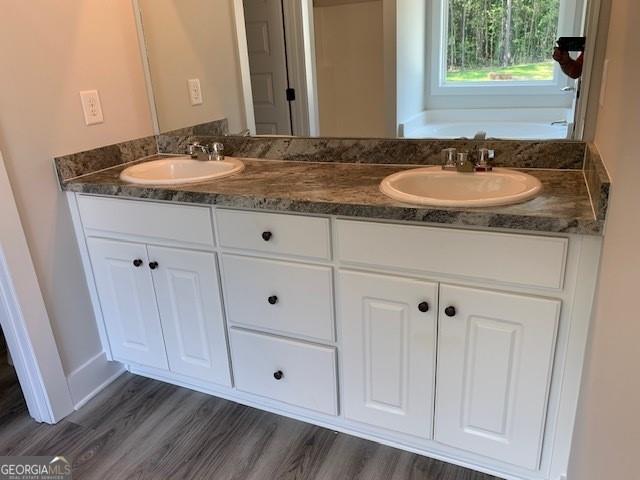 453 Riley Cir, Milledgeville, GA 31061 - full bath featuring double vanity, a garden tub, and wood finished floors