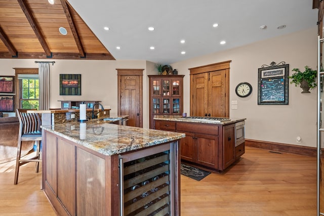 kitchen featuring stainless steel appliances, wine cooler, a large island, and light hardwood / wood-style flooring