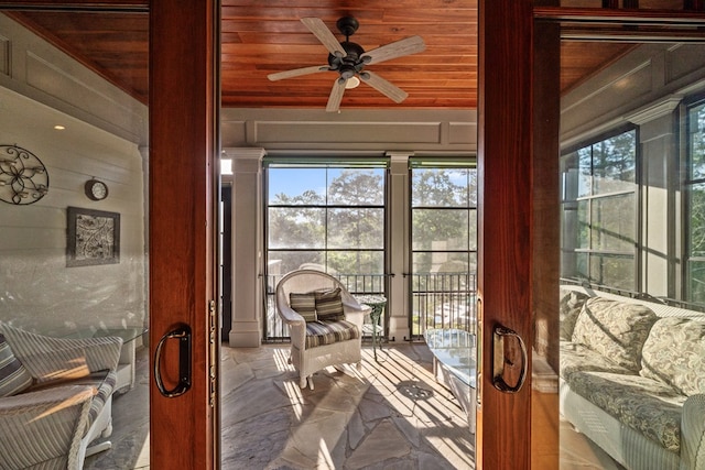 sunroom featuring ceiling fan and wood ceiling