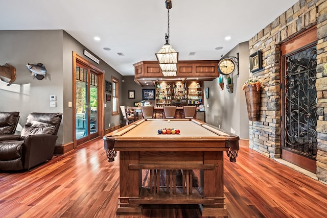 recreation room with hardwood / wood-style floors, pool table, and indoor bar