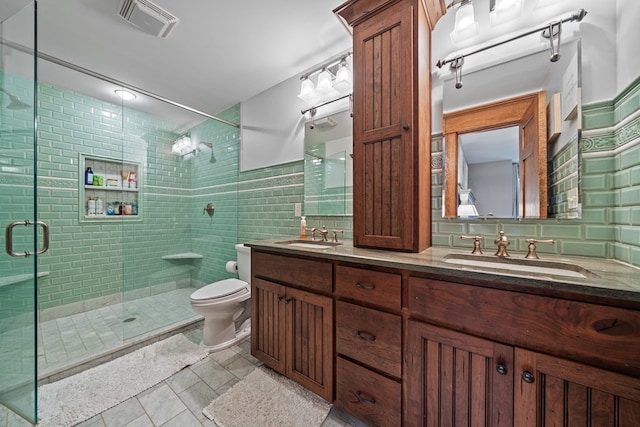 bathroom with vanity, tile patterned floors, toilet, tile walls, and walk in shower