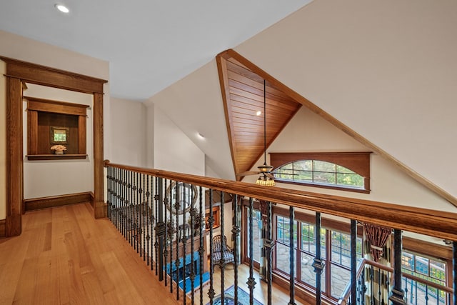 corridor with light hardwood / wood-style flooring and lofted ceiling