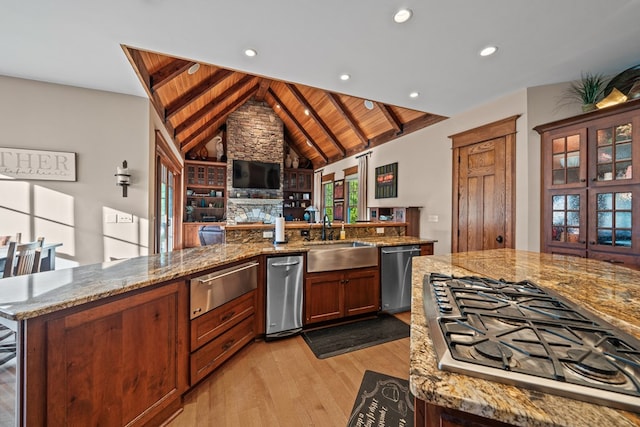 kitchen featuring a center island, lofted ceiling with beams, sink, appliances with stainless steel finishes, and wood ceiling