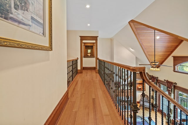 corridor featuring light hardwood / wood-style floors, wooden ceiling, and a healthy amount of sunlight