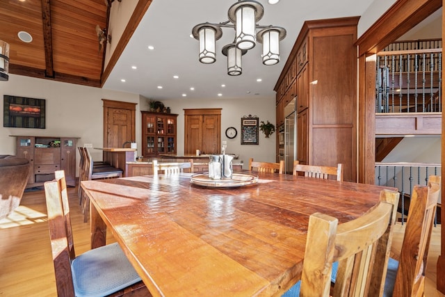 dining room featuring high vaulted ceiling, an inviting chandelier, light hardwood / wood-style flooring, beamed ceiling, and wood ceiling