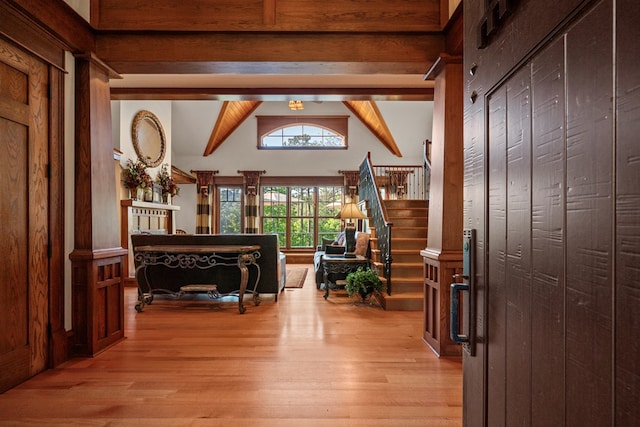 hall featuring beam ceiling, light hardwood / wood-style floors, and high vaulted ceiling