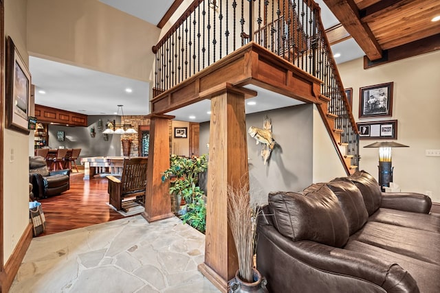 living room with beam ceiling and decorative columns