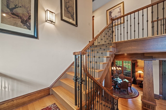 stairway featuring hardwood / wood-style floors and a chandelier