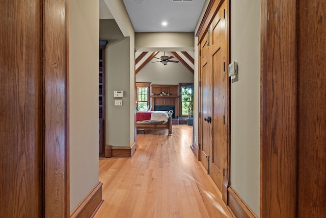 hall featuring vaulted ceiling with beams and light hardwood / wood-style floors