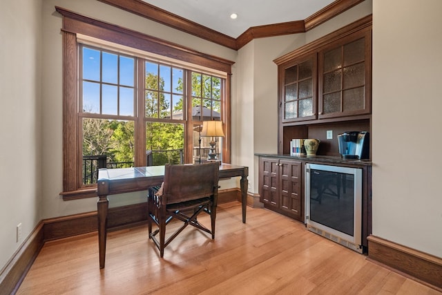 office space with ornamental molding, beverage cooler, and light hardwood / wood-style floors