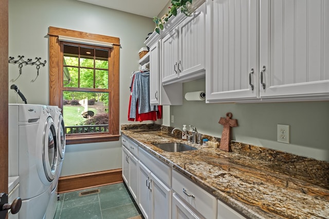 clothes washing area featuring washer and dryer, cabinets, and sink