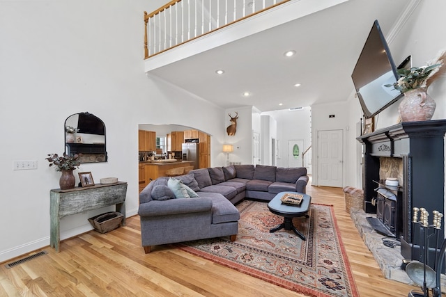793 Greene Settlement Rd, Gray, GA 31032 - living area with light wood-type flooring, arched walkways, a towering ceiling, crown molding, and recessed lighting