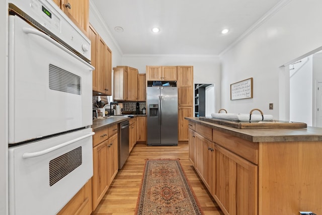 793 Greene Settlement Rd, Gray, GA 31032 - kitchen featuring appliances with stainless steel finishes, crown molding, light wood-style flooring, dark countertops, and tasteful backsplash