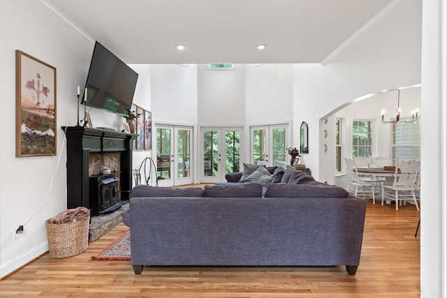 793 Greene Settlement Rd, Gray, GA 31032 - living room with a chandelier, crown molding, light wood-style flooring, arched walkways, and a fireplace with raised hearth