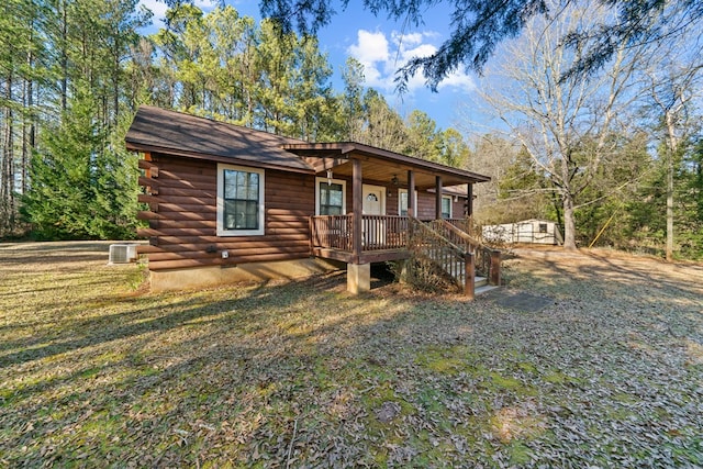 log home featuring a porch, central air condition unit, and a front lawn