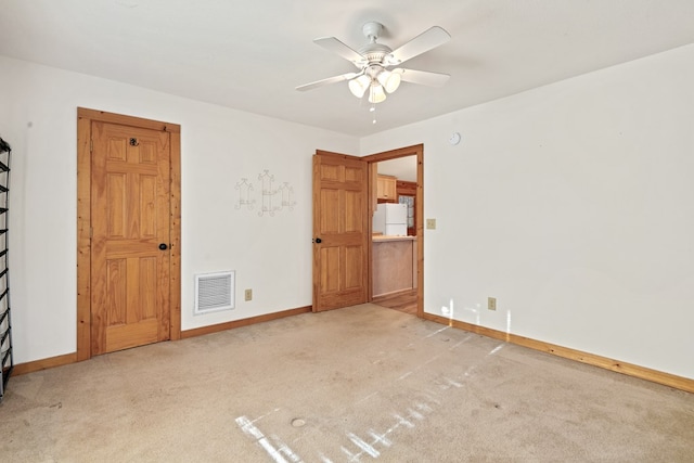 unfurnished room featuring light carpet and ceiling fan