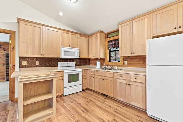 kitchen with white appliances, vaulted ceiling, light brown cabinets, sink, and light wood-type flooring