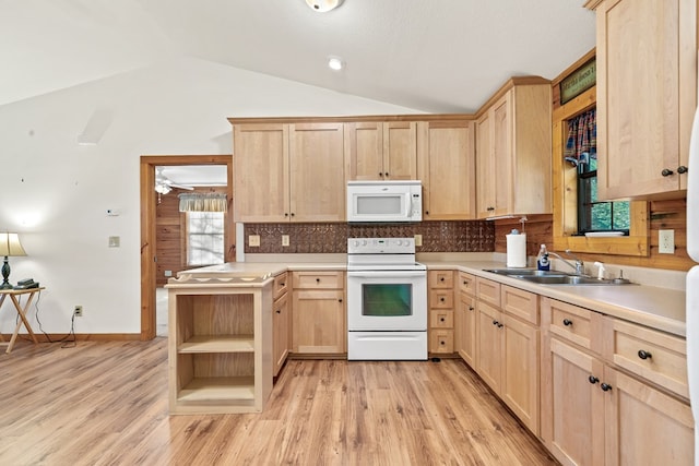 kitchen featuring vaulted ceiling, light brown cabinets, and white appliances