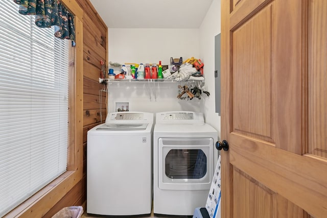 laundry area featuring wooden walls and washing machine and clothes dryer