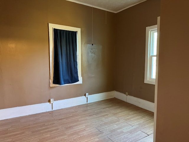 spare room featuring light hardwood / wood-style floors and ornamental molding