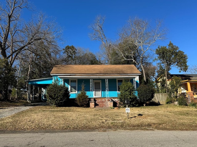 view of front of property with a carport, covered porch, and a front yard