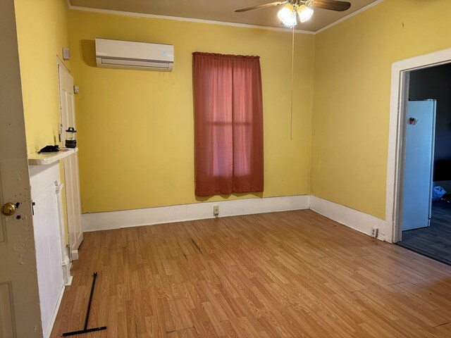 interior space featuring light wood-type flooring, crown molding, and a wall mounted AC