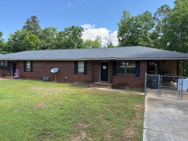 ranch-style house with a front lawn, driveway, brick siding, and a gate