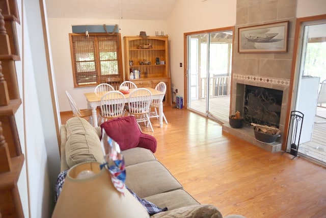 living room featuring wood finished floors, vaulted ceiling, and a fireplace