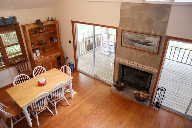 dining space featuring light wood finished floors and a tiled fireplace