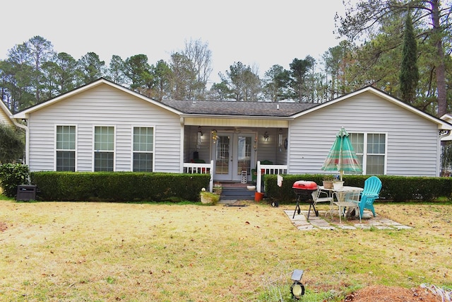 rear view of property featuring a yard and a porch