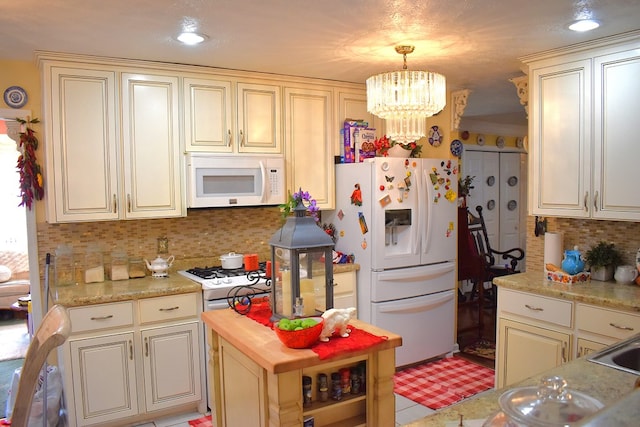 kitchen featuring pendant lighting, white appliances, cream cabinets, and backsplash