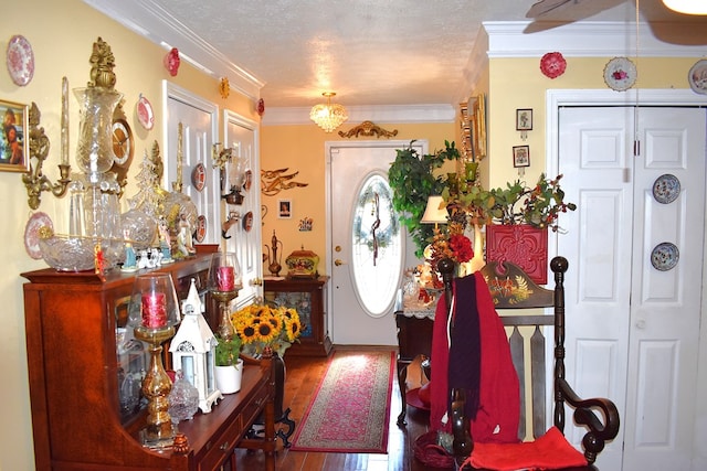 foyer with hardwood / wood-style flooring, ornamental molding, and a textured ceiling