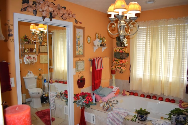 bathroom with toilet, a chandelier, tile patterned flooring, and a washtub