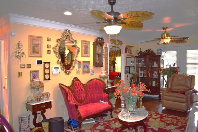 living room featuring hardwood / wood-style flooring, ornamental molding, a textured ceiling, and ceiling fan