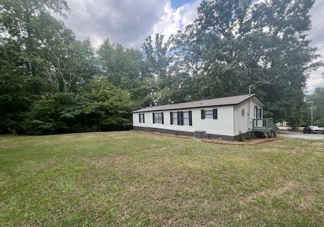 exterior space with a lawn and central air condition unit