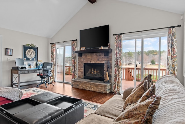 living room featuring hardwood / wood-style flooring, a fireplace, high vaulted ceiling, and beam ceiling