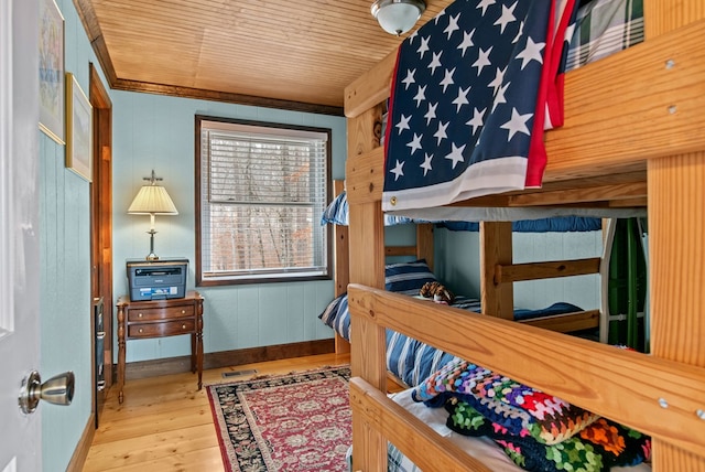 bedroom with hardwood / wood-style flooring, wood ceiling, and crown molding