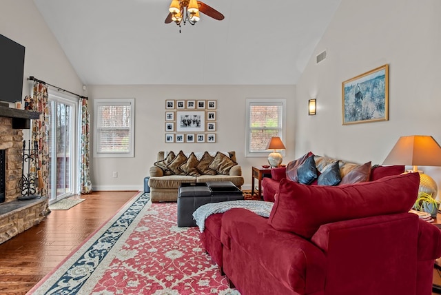 living room with ceiling fan, high vaulted ceiling, a fireplace, and hardwood / wood-style floors