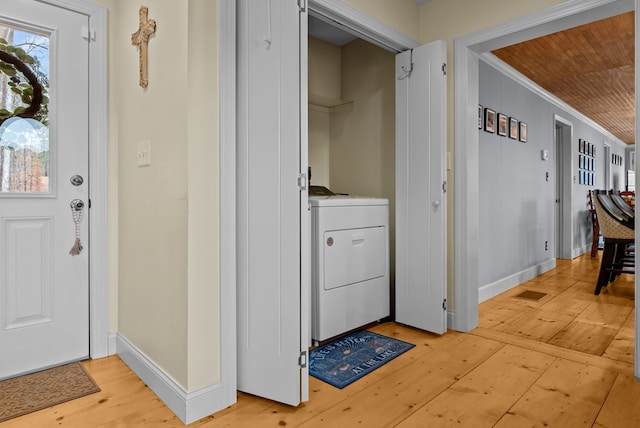 interior space featuring ornamental molding, washer / dryer, and light wood-type flooring