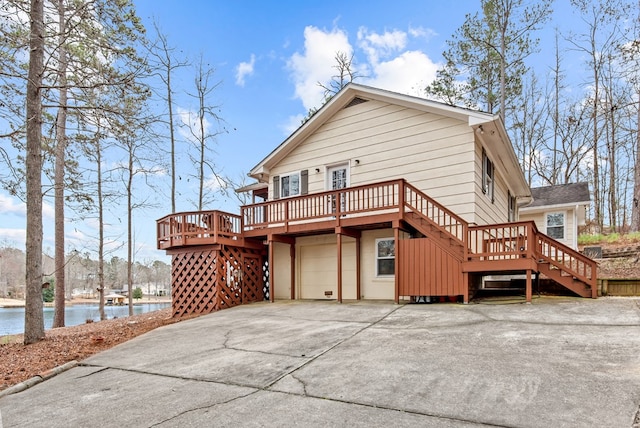 back of house with a deck with water view and a garage