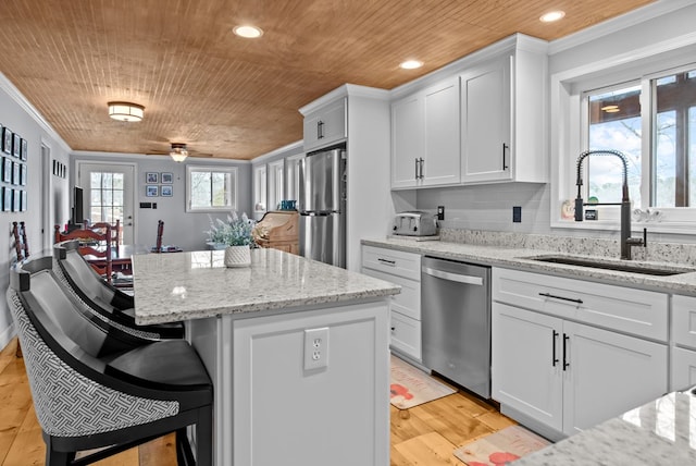 kitchen with stainless steel appliances, white cabinetry, sink, and wooden ceiling