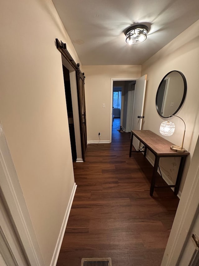 corridor featuring dark hardwood / wood-style flooring and a barn door