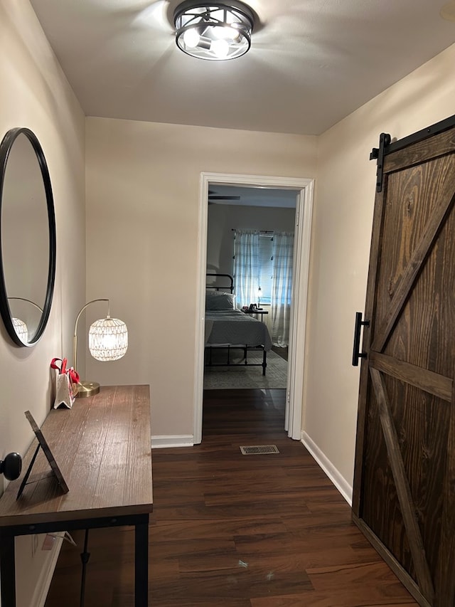 hallway featuring dark hardwood / wood-style floors and a barn door